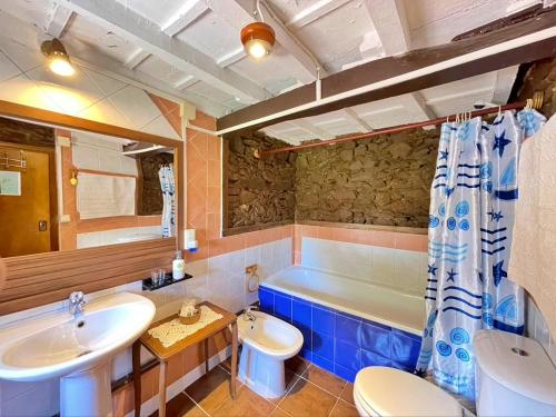 ein Badezimmer mit einer Badewanne, einem WC und einem Waschbecken in der Unterkunft La AsturXana in Malleza