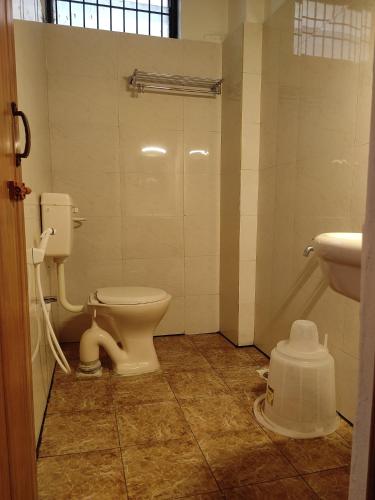 a bathroom with a toilet and a sink at Ashray Residency in Vānivilāsa Puram