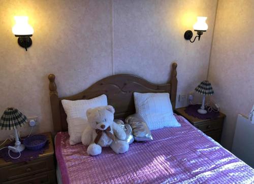 a teddy bear sitting on top of a bed at Leśna Cisza w Ładnówku 1 in Kruszyny Szlacheckie