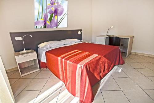 una camera con un letto con una coperta rossa di Il Fiore in una Stanza a Itri