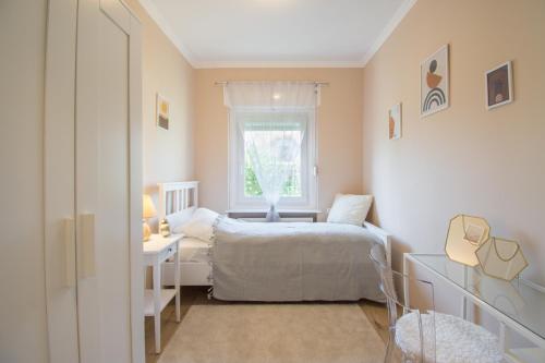 ein kleines Schlafzimmer mit einem Bett und einem Fenster in der Unterkunft 101 Apartman Agárd,Török Bálint utca 101 in Agárd