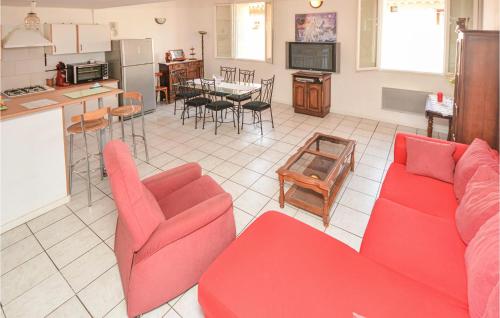 a living room with a red couch and a kitchen at Holiday Home Cessenon Sur Orb Mn-1265 in Cessenon