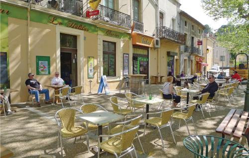 a group of people sitting at tables and chairs on a street at Holiday Home Cessenon Sur Orb Mn-1265 in Cessenon