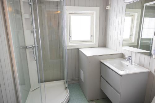 a bathroom with a toilet and a sink and a shower at The Tide - Rorbuer in Sørvågen