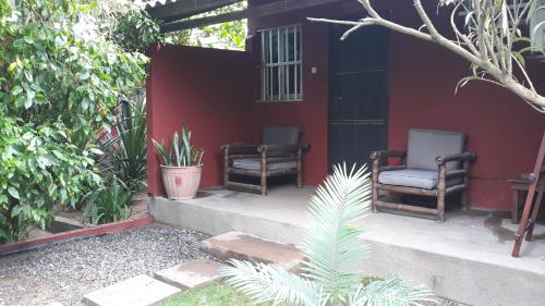 two chairs sitting on the porch of a house at Hotel Robinson Plage in Lomé