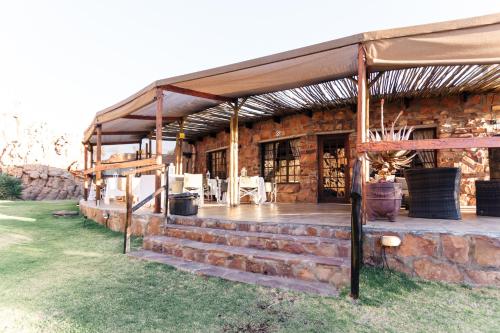 a brick building with a tent and a table and chairs at Kagga Kamma Nature Reserve in Lochlynne