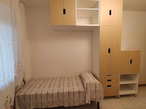 a small bedroom with a bed and a cabinet at Apartment in Sardinia in Decimomannu