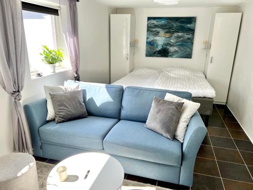 a living room with a blue couch and a bed at Casa Tureholm - ett mysigt hus i idylliska Trosa in Trosa