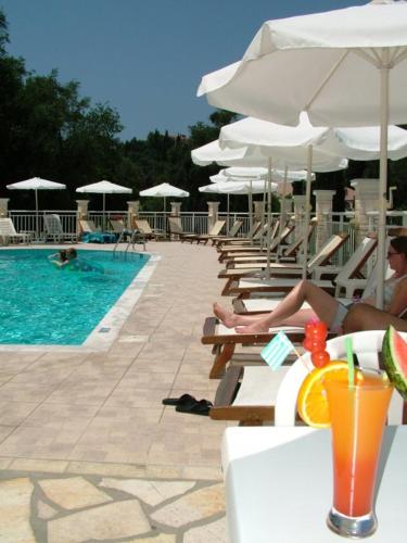 a group of people sitting on chairs next to a swimming pool at Alexander in Agios Gordios