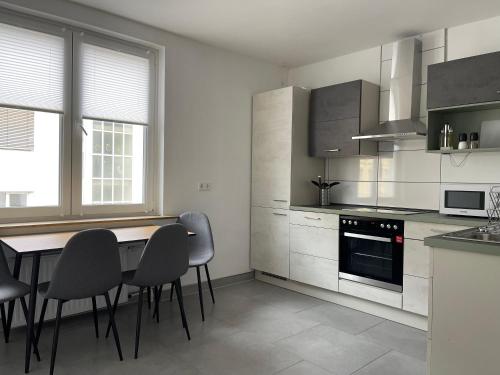 a white kitchen with a table and chairs in it at Moderne Studios im Herzen von Osnabrueck in Osnabrück