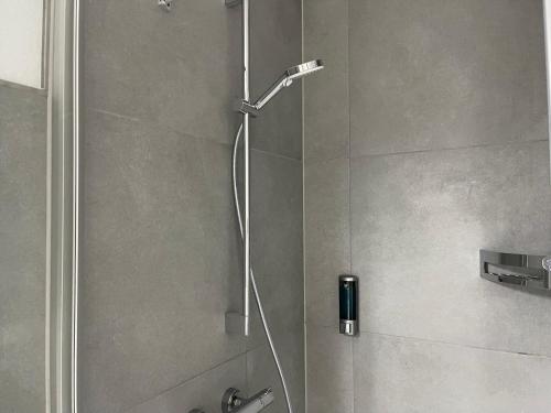 a shower with a shower head in a bathroom at Moderne Studios im Herzen von Osnabrueck in Osnabrück