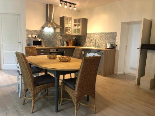une cuisine avec une table et des chaises en bois dans l'établissement Maison de campagne Chez Georges, à Saint-Sulpice-de-Pommiers