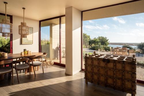uma cozinha e sala de jantar com uma mesa e uma grande janela em Casa da Ria em Tavira