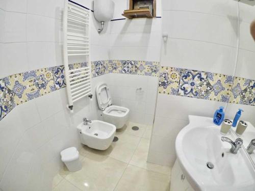 La salle de bains blanche est pourvue de toilettes et d'un lavabo. dans l'établissement Corner Terrace Sorrento Coast, à Sant'Agnello