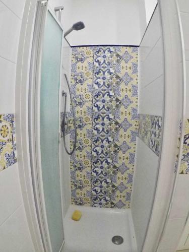 La salle de bains est pourvue d'une douche avec du carrelage bleu et blanc. dans l'établissement Corner Terrace Sorrento Coast, à Sant'Agnello