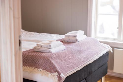 a bedroom with a bed with towels on it at The Tide - Rorbuer in Sørvågen