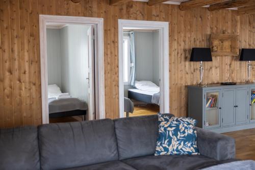a living room with a couch and a bedroom at The Tide - Rorbuer in Sørvågen