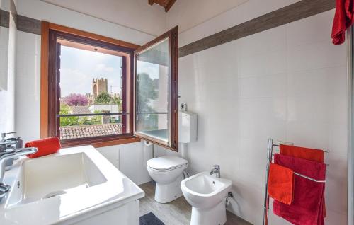 een badkamer met een wastafel, een toilet en een raam bij Cosy Apartment in the heart of the medioeval Walls in Montagnana