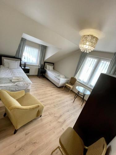 a bedroom with a bed and a couch and chairs at Zajazd Arkadia in Siemiatycze