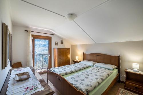 a bedroom with a large bed and a window at La Mansarda di Chiara e Silvio in Trasquera