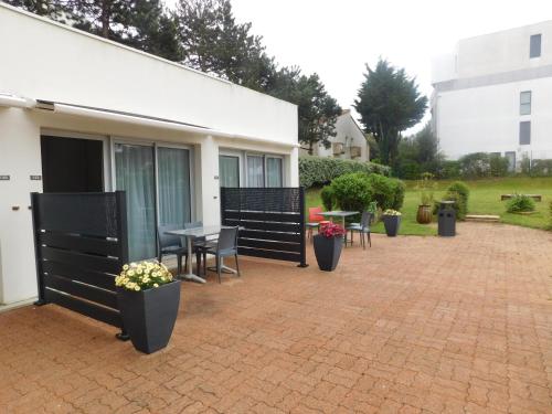 a patio with a table and chairs and plants at Résidence New Rochelle in La Rochelle