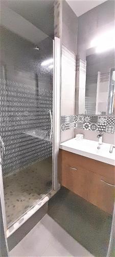 une salle de bain avec une douche, un lavabo et un miroir dans l'établissement Villa Village Naturiste Karess, au Cap d'Agde