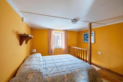 - une chambre jaune avec un grand lit dans l'établissement Casa Comero, à Trasquera