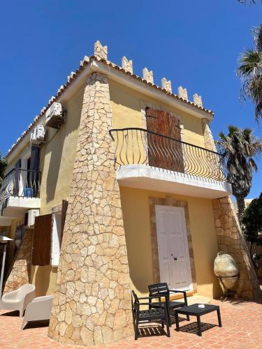 - un bâtiment avec un balcon et une table en face dans l'établissement Villa Sofia, à Lampedusa