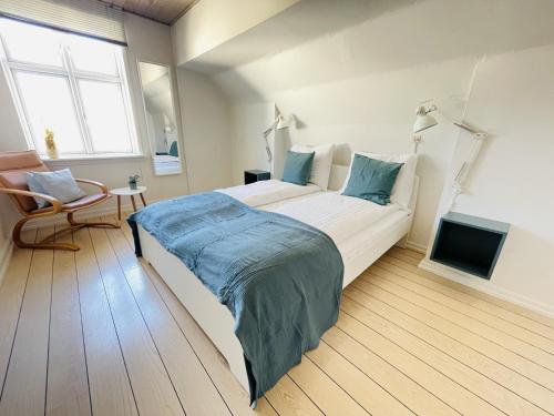 a bedroom with a large white bed with blue sheets at aday - Frederikshavn City Center - Room 5 in Frederikshavn