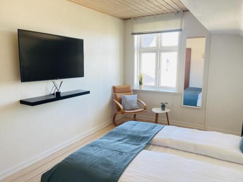 Schlafzimmer mit einem Bett und einem Flachbild-TV in der Unterkunft aday - Frederikshavn City Center - Room 5 in Frederikshavn