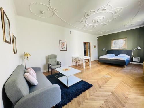 a living room with a couch and a bed at aday - Frederikshavn City Center - Luxurious room in Frederikshavn