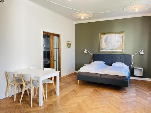 a bedroom with a bed and a table and chairs at aday - Frederikshavn City Center - Luxurious room in Frederikshavn