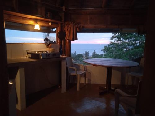 eine Küche mit einem Tisch und ein Fenster mit Aussicht in der Unterkunft Punto Verde Ecological house in Montañita
