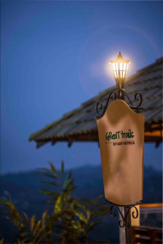 a light on a pole with a sign on it at GReaT Trails Wayanad by GRT Hotels in Wayanad