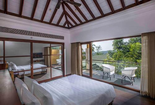 a bedroom with a bed and a balcony at GReaT Trails Wayanad by GRT Hotels in Wayanad
