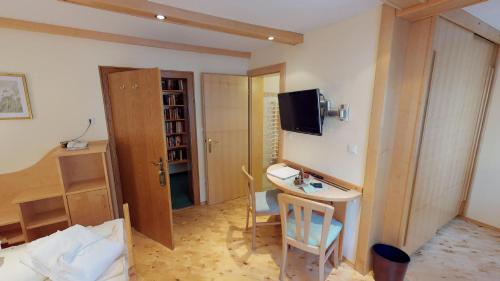 a room with a table and a tv on the wall at Das kleine Familienhotel Koch in Eisentratten