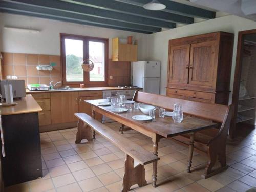 - une cuisine avec une table et un banc en bois dans l'établissement LE PETIT FROUAS NORD, à Vielle-Saint-Girons