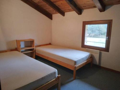 une chambre avec deux lits et une fenêtre dans l'établissement LE PETIT FROUAS NORD, à Vielle-Saint-Girons