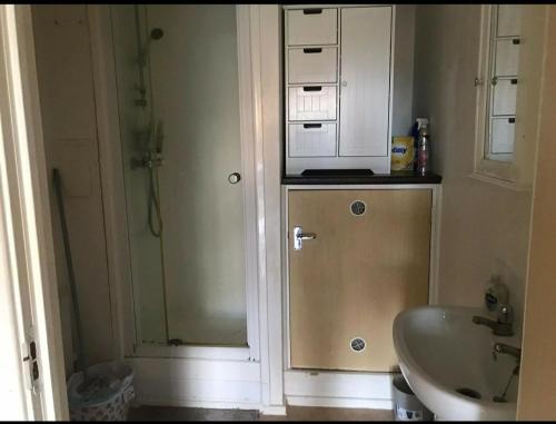 La petite salle de bains est pourvue d'un lavabo et d'un four micro-ondes. dans l'établissement Immaculate 1-Bed Apartment in Stoke-on-Trent, à Stoke-on-Trent