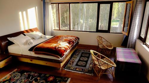 a bedroom with a bed in a room with windows at Ladakh Eco House in Leh