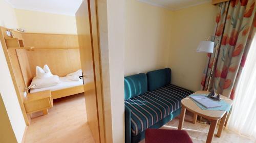 a small room with a couch and a bed at Das kleine Familienhotel Koch in Eisentratten