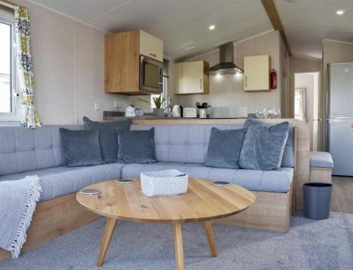 a living room with a blue couch and a table at 2 Bed - Sleeps 6 - 15min Walk to Beach in Morecambe