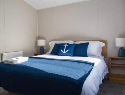 a bedroom with a large bed with blue and white sheets at Brand New 2 Bedroom Lodge Perfect for Families in Morecambe