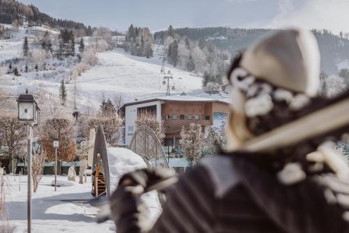 a person is holding a snowboard in the snow at Hotel Berghof - St Johann in Salzburg in Sankt Johann im Pongau