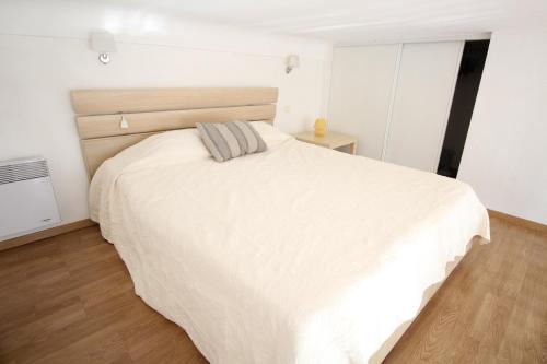 - un lit blanc dans une chambre dotée de parquet dans l'établissement CASA MARE, à Nice