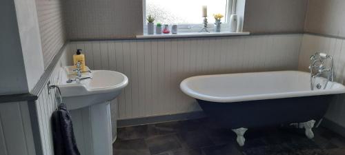 a bathroom with a bath tub and a sink at Cosy and stylish house on the coast near Liverpool in Wirral