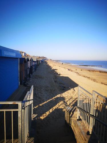 a row of beach huts on a sandy beach at Lovely 2-Bed caravan in Walton on the Naze in Walton-on-the-Naze