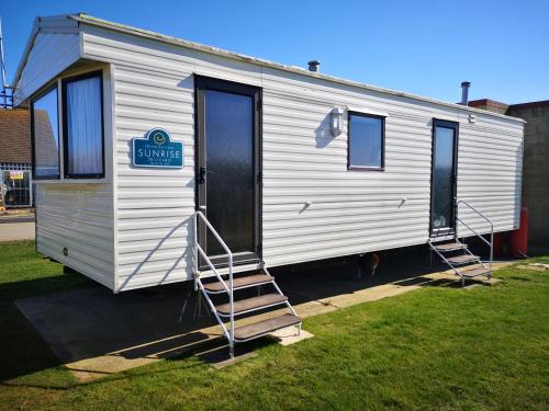 a small white trailer with a sign on it at Lovely 2-Bed caravan in Walton on the Naze in Walton-on-the-Naze