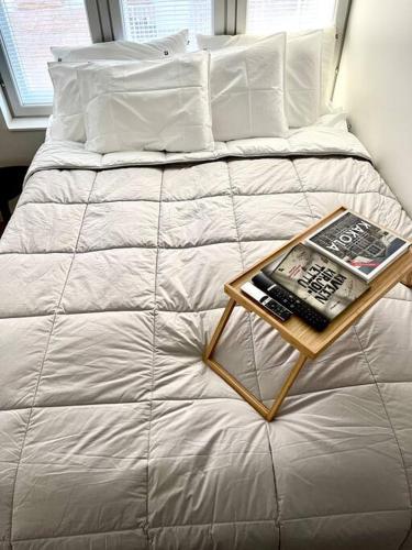 Una cama con una bandeja con un libro. en Ihana huoneisto Turun Kakolassa en Turku