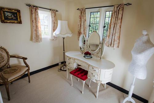 a dressing table with a mirror and a lamp in a room at Breathtaking Elizabethan Manor House in Burnham on Crouch